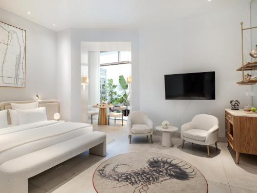 a bedroom with a bed and a tv on a wall at The Dolli at Acropolis, A Hotel to Live in Athens