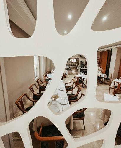 a restaurant with white walls and tables and chairs at Hoteles Urbanos N Avenida de España in Fuenlabrada