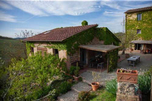 a house covered in ivy with a table in front of it at Agriturismo & Winery Il Bacio in Tavarnelle in Val di Pesa