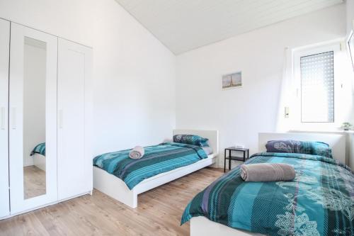 1 dormitorio con 2 camas y espejo en nJoy! Sunny & Spacious - Balkon - WLAN - Parkplatz - perfekt für Work & Travel en Göppingen