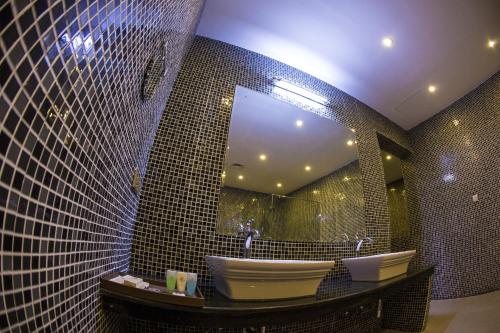 a bathroom with a mirror and a tub and a sink at Grand Tamarind Lake in Kataragama