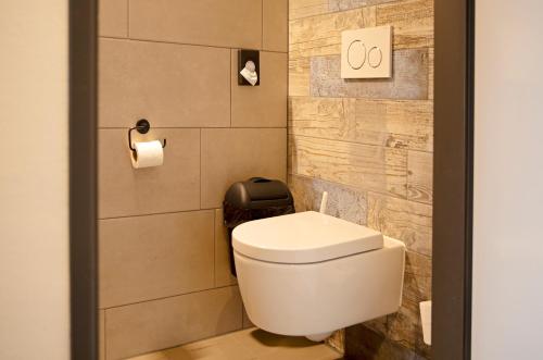 uma casa de banho com um WC branco num quarto em Hotel Restaurant Eeserhof em Ees