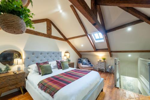 a bedroom with a large bed in a attic at Little Apple- Free Parking, Hot tub, Fire, Town Centre in Appleby