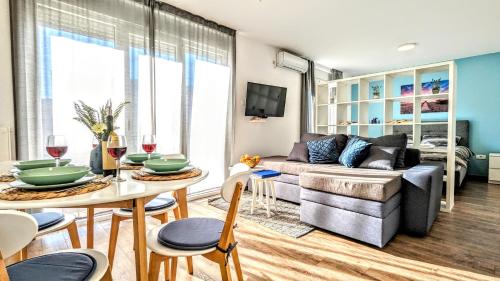 een woonkamer met een bank en een tafel bij Blue Lagoon 150m-2 minuta hoda od centra, mogucnost za parking-apartmani-nsmilos in Novi Sad