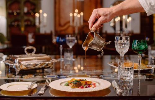 a person is pouring a tablespoon of food on a table at Castello Di Casalborgone in Casalborgone