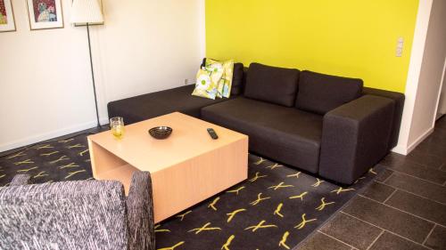 a living room with a couch and a table at Hotel Strandtangen in Skive