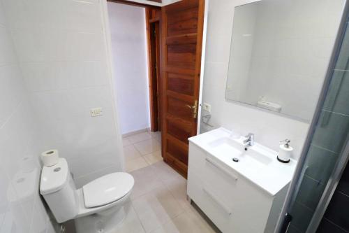 W łazience znajduje się toaleta, umywalka i lustro. w obiekcie Parque Santiago I 242 by Tenerife Rental and Sales w Playa de las Americas