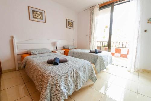 sypialnia z 2 łóżkami i ręcznikami w obiekcie Parque Santiago I 242 by Tenerife Rental and Sales w Playa de las Americas