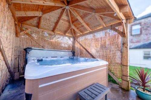 bañera de hidromasaje en un cenador con techo de madera en Little Apple- Free Parking, Hot tub, Fire, Town Centre, en Appleby