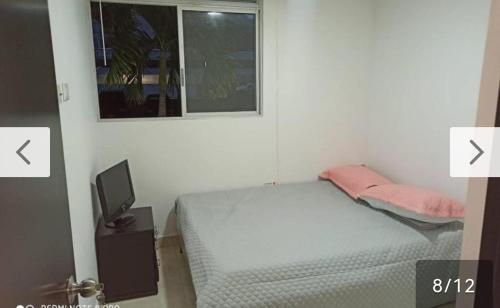 a small bedroom with a bed and a window at Hermoso apartamento con excelente ubicación in Ibagué