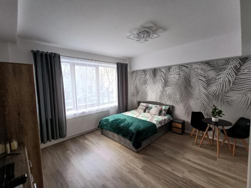 a bedroom with a bed and a window and a table at Apartamenty Centrum- Wojska Polskiego in Słupsk