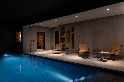 - une piscine avec des chaises et des tables dans une chambre dans l'établissement Hôtel Pilgrim, à Paris