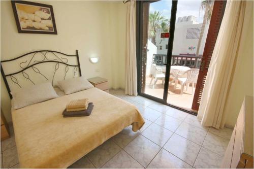 a bedroom with a large bed and a balcony at Parque Santiago II 160 by Tenerife Rental and Sales in Playa de las Americas