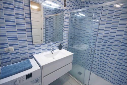a bathroom with a white sink and a mirror at Parque Santiago II 160 by Tenerife Rental and Sales in Playa de las Americas