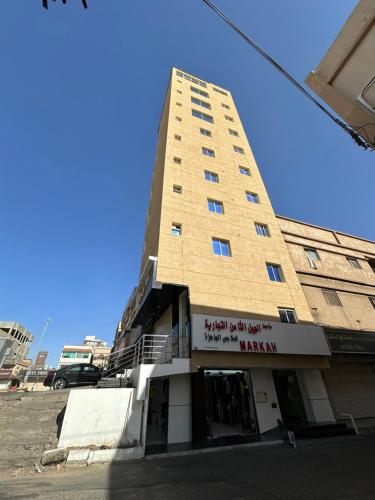 um edifício alto com uma placa na lateral em برج موجان السكني التجاري em Khamis Mushayt