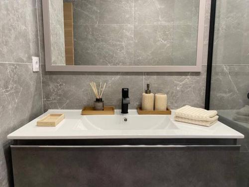 une salle de bain avec un lavabo blanc et un miroir dans l'établissement Monaco One bedroom apartment with Panoramic sea view, à Roquebrune-Cap-Martin