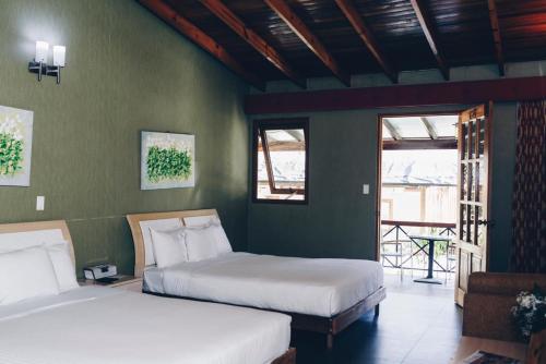 2 camas en una habitación con paredes verdes en tierras altas casa grande, en Bambito