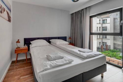 een slaapkamer met een groot bed en een raam bij Apartament z widokiem na rzekę by Grand Apartments in Gdańsk