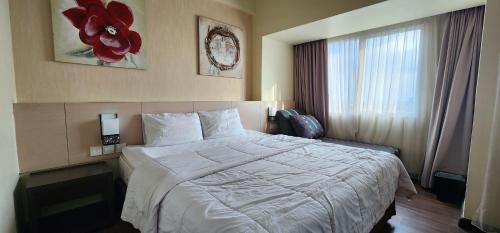 Un pat sau paturi într-o cameră la Apartemen Solo Paragon by Cariapartemen-id