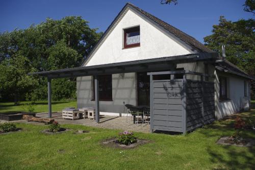 a white house with a garage and a table at Ferienhaus Mitteldeich in Butjadingen