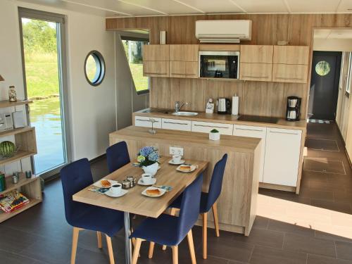 a kitchen and dining room with a wooden table and chairs at Hausboot Ueckermuende in Ueckermünde
