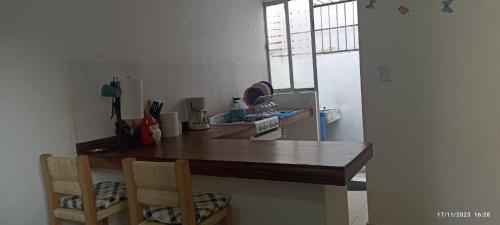 een keuken met een houten bureau en 2 stoelen bij ZIHUA TAANAJ in Zihuatanejo