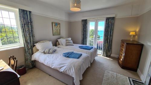 a bedroom with two beds and a window at The White House in Saint Mawes