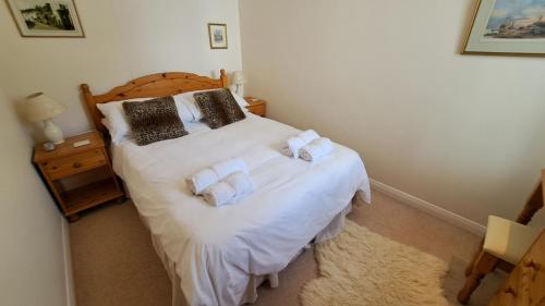 a bedroom with a white bed with towels on it at Rosemullion in Saint Mawes