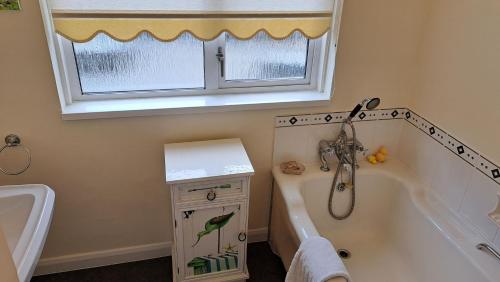 a bathroom with a tub and a bird on the window at Rosemullion in Saint Mawes