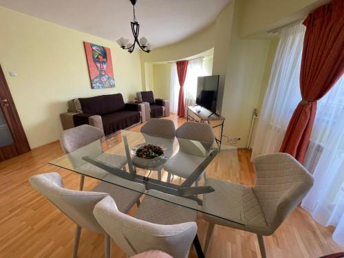 a living room with a glass table and chairs at House of Parliament Ultracentral Apartament self check in in Bucharest