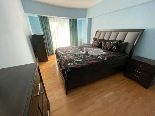 ein Schlafzimmer mit einem großen Bett und einer Kommode in der Unterkunft House of Parliament Ultracentral Apartament self check in in Bukarest
