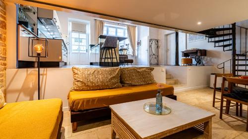 a living room with a yellow couch and a table at Le Chouette Loft in Dijon