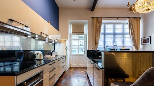 a large kitchen with black counter tops andwindows at Le Chouette Loft in Dijon