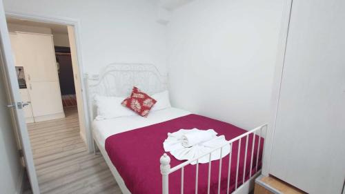 ein kleines Schlafzimmer mit einem Kinderbett mit einer lila Decke in der Unterkunft Eurostar City Apartments in London