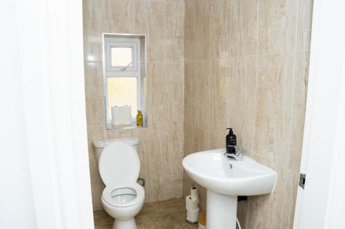 y baño con aseo y lavamanos. en Large Ideal Accommodation for Groups & Contractors en Horsforth