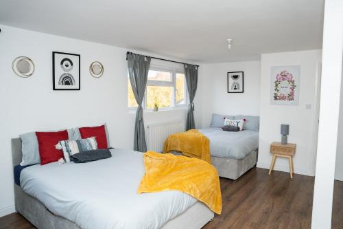 een slaapkamer met 2 bedden en een raam bij Large Ideal Accommodation for Groups & Contractors in Horsforth