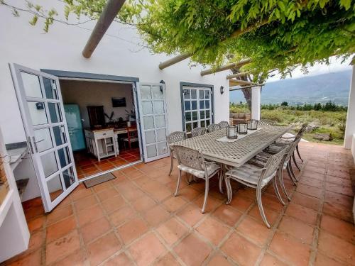 comedor con mesa y sillas en el patio en The Oaks Tulbagh, en Tulbagh