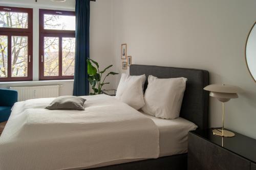 1 dormitorio con 1 cama con sábanas y almohadas blancas en Große familienfreundliche Wohnung in Dresden en Dresden