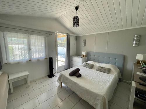 a bedroom with a bed with a teddy bear on it at Résidence île de beauté in Propriano