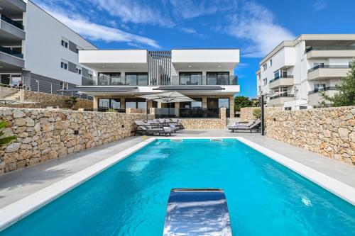 a villa with a swimming pool in front of a building at Luxury Villas Great Escape & Noa in Novalja