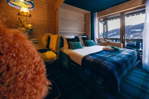 a bedroom with a bed and a large window at Mamie Megève in Megève