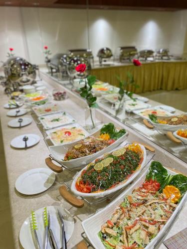 a buffet with many plates of food on a table at Triple Tree Serviced Unites in Al Hofuf