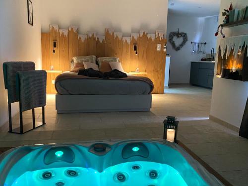 a bedroom with a bed and a tub in the foreground at LOVE AND BULLES in Le Fleix