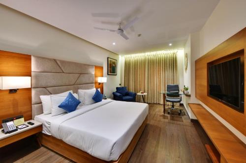 a hotel room with a bed and a television at The Fern Residency Ajmer in Ajmer