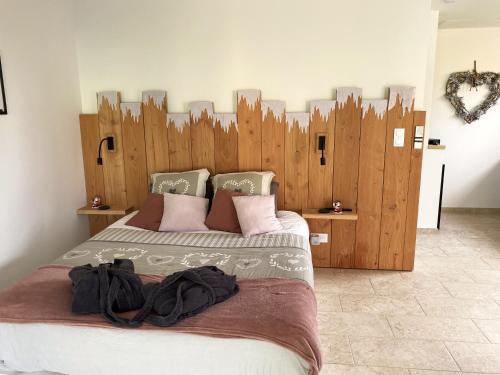 a bedroom with a large bed with a wooden headboard at LOVE AND BULLES in Le Fleix