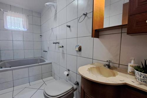y baño con lavabo, aseo y bañera. en Casa Familiar em Bento Gonçalves, en Bento Gonçalves
