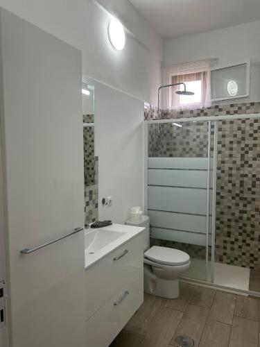 a white bathroom with a toilet and a shower at Finca la Gaviota - Terazza-Jacuzzi con vistas al teide in Icod de los Vinos