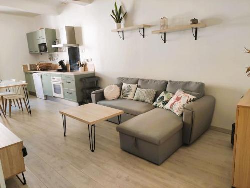 ein Wohnzimmer mit einem Sofa und einem Tisch in der Unterkunft Charmant appartement entier 4 pers proche Aix in Gardanne