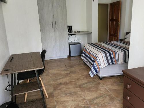 a bedroom with a bed and a desk and a table at SABLE INN B&B in Modimolle