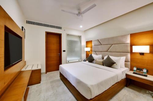 a bedroom with a large bed and a flat screen tv at The Fern Residency Ajmer in Ajmer